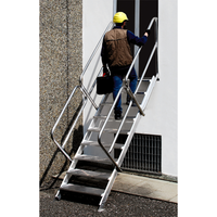 Escabeau en aluminium fixé sur un bâtiment, offrant un accès sécurisé pour le travail en hauteur.